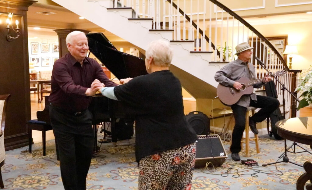 residents dancing to a live perform playing guitar