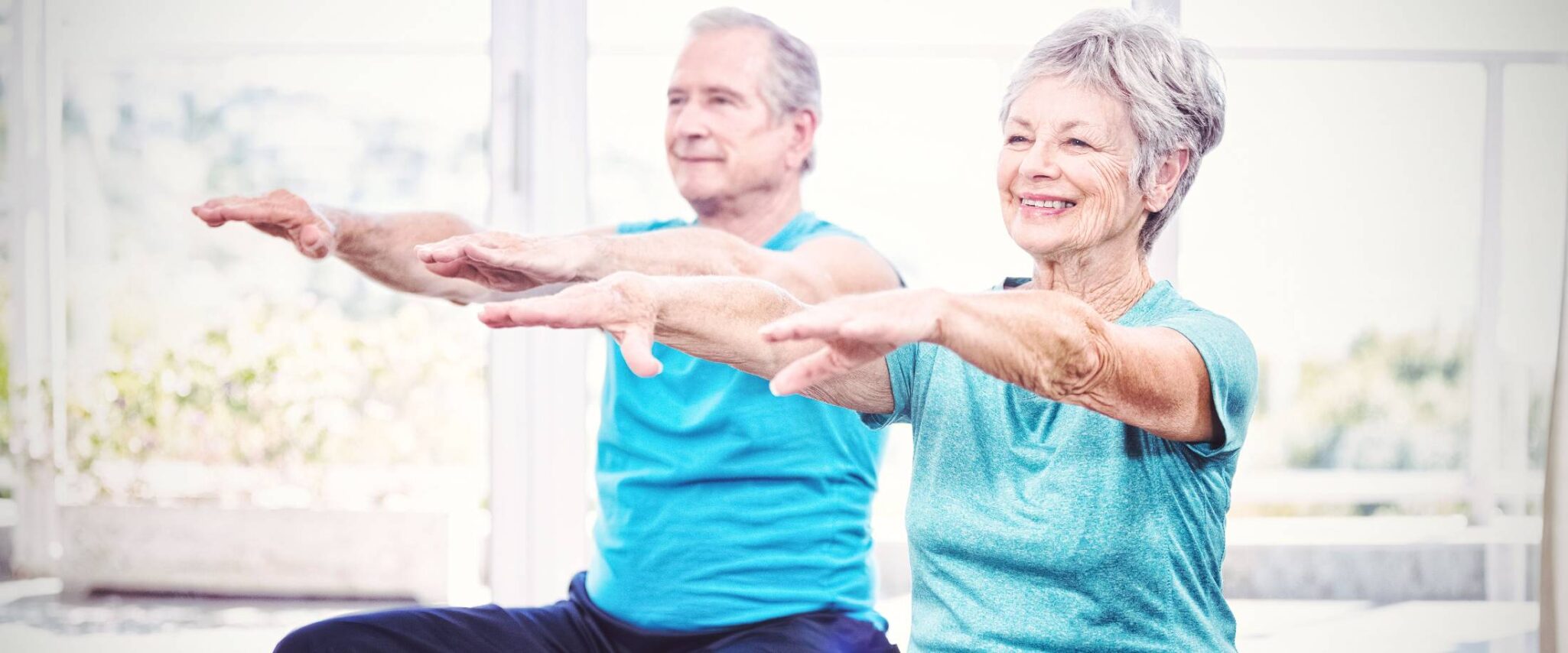 two seniors practicing pilates at a senior living community