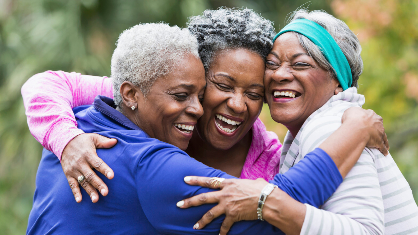 Group of three senior friends embracing