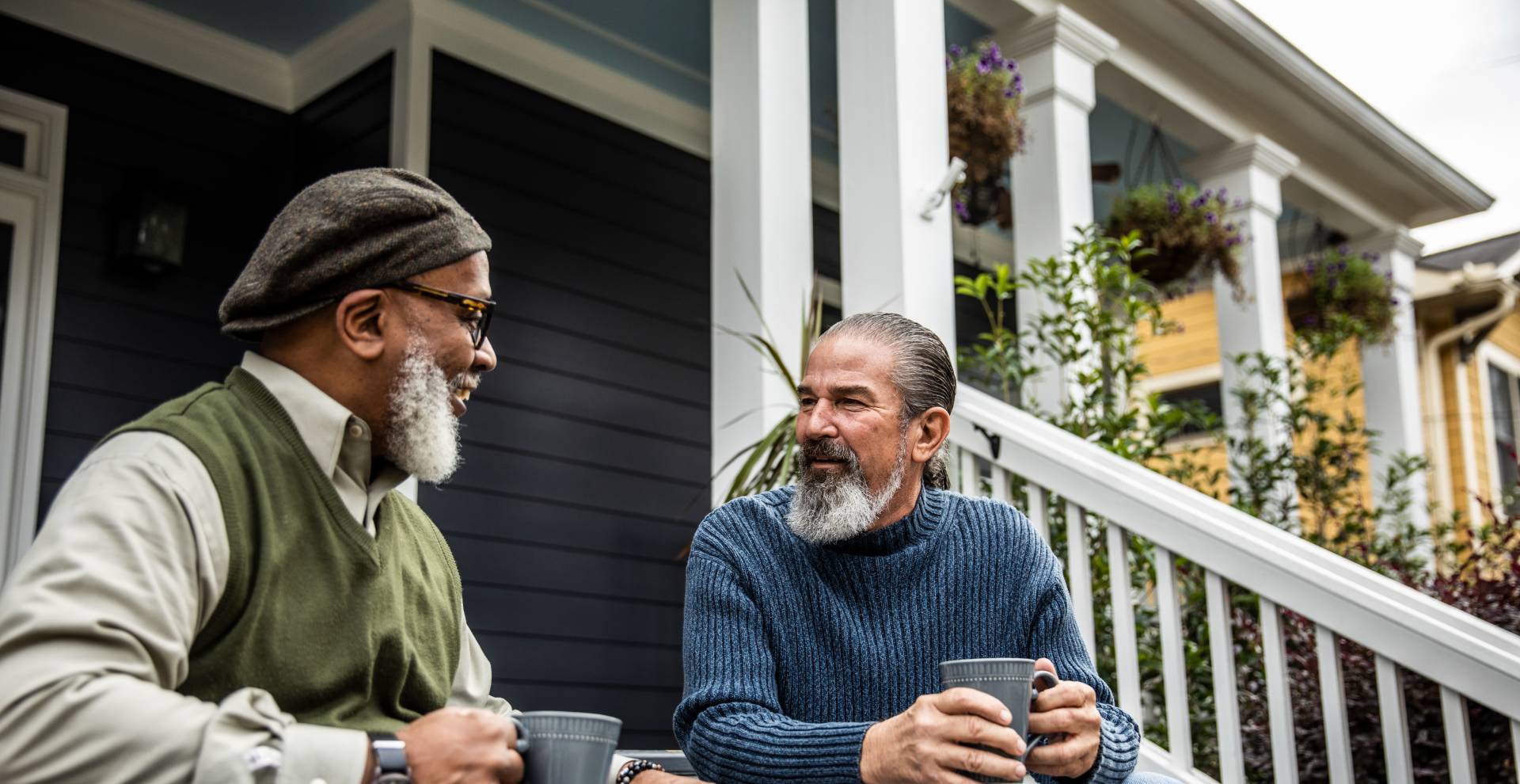 two seniors talking and enjoying a cup of coffee on the porch