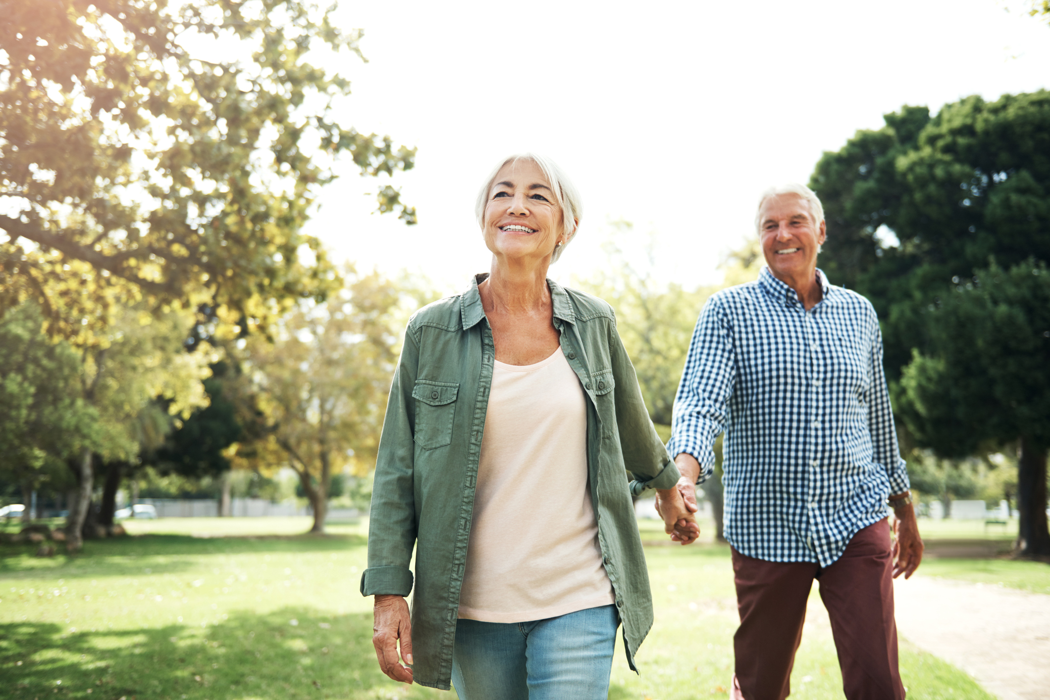 happy senior couple going for a walk in the park