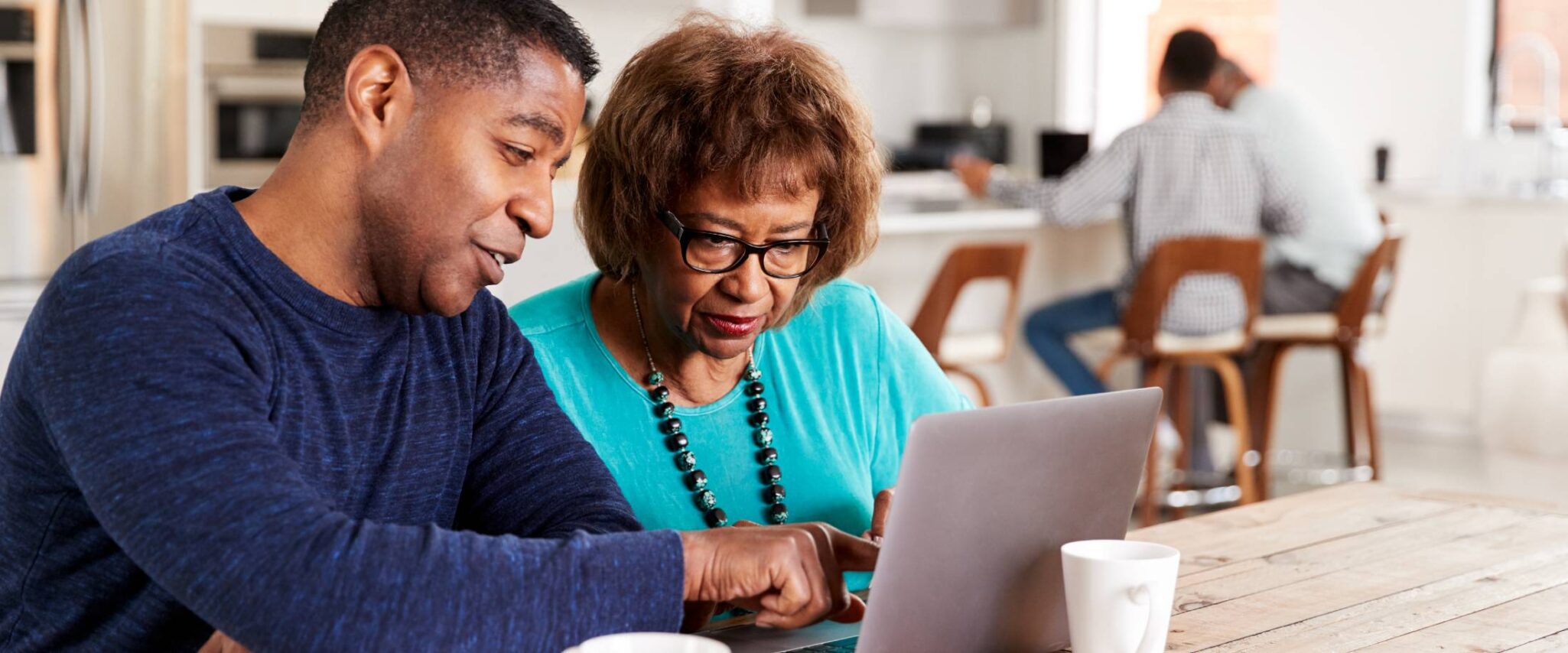 senior lady and adult son looking on a laptop together