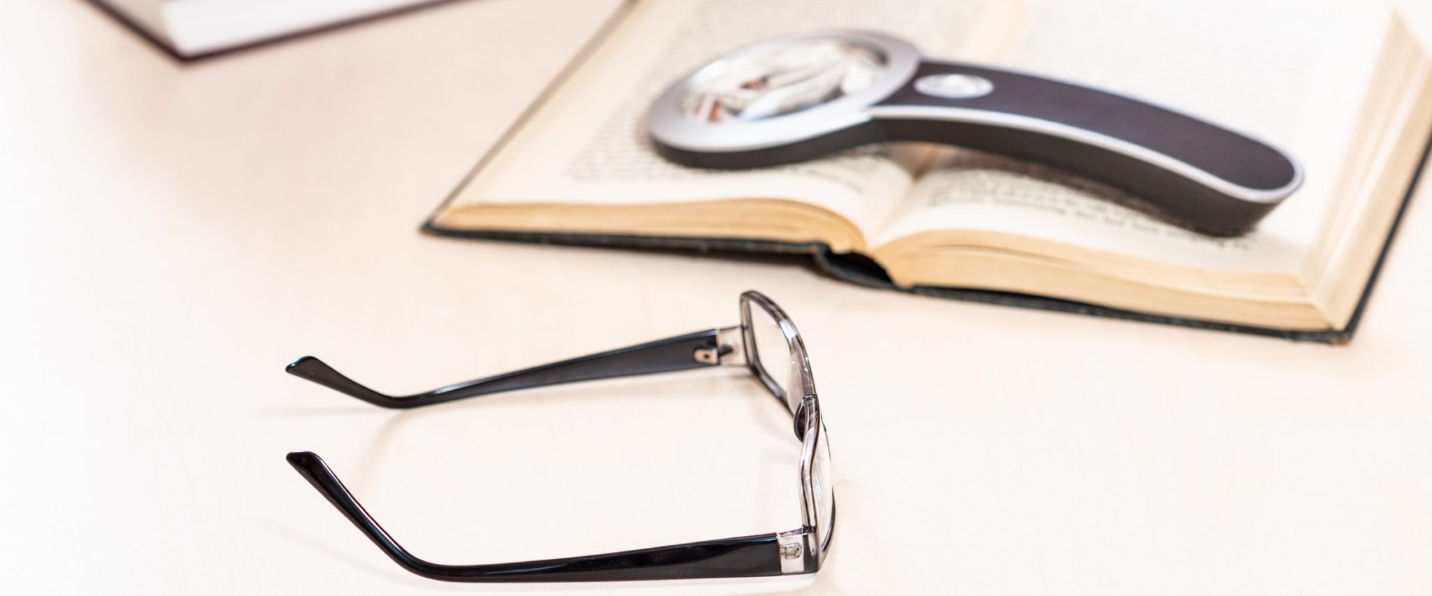 reading glasses and a magnifying glass for seniors with low vision