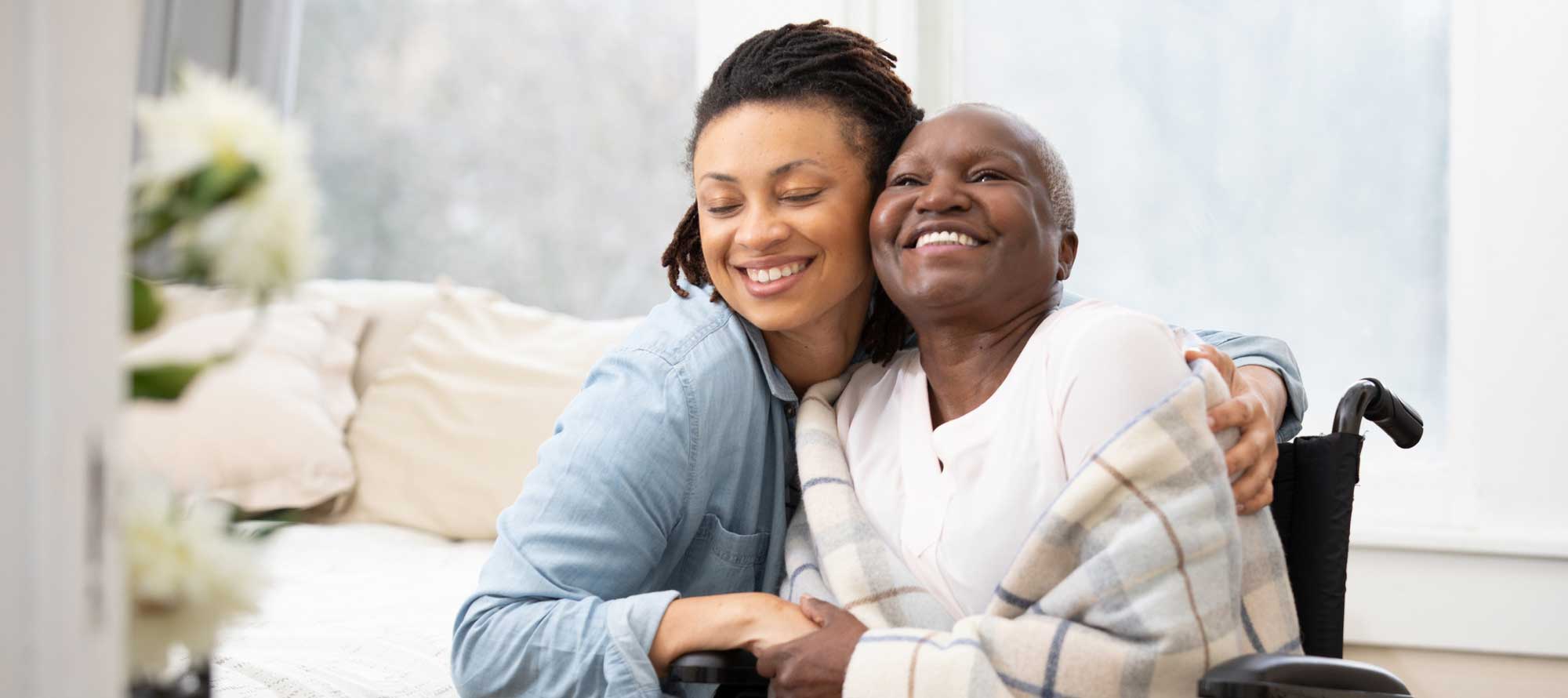 Mother and daughter hugging inside senior living community