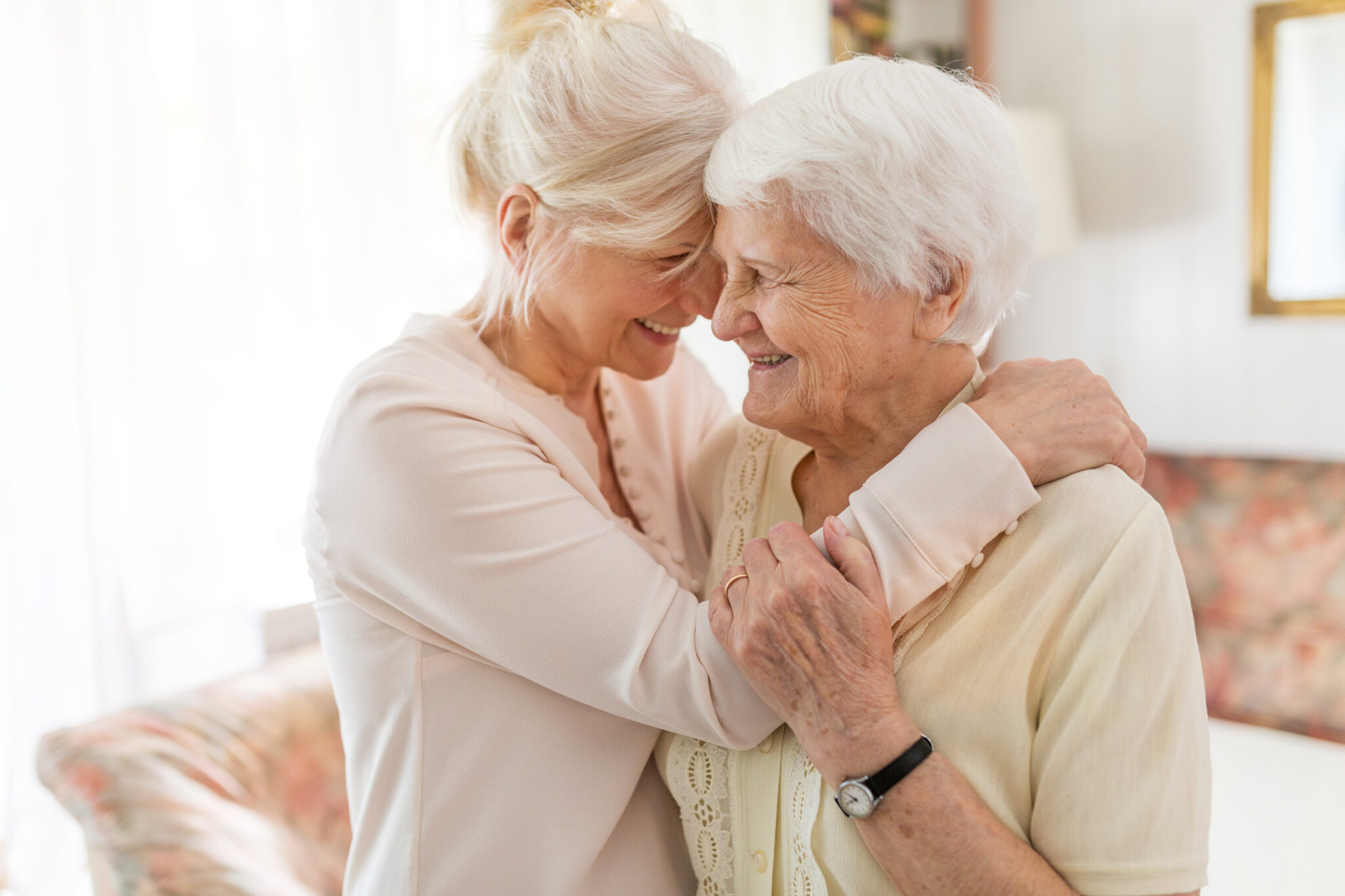 Older adult woman hugging her elderly mother