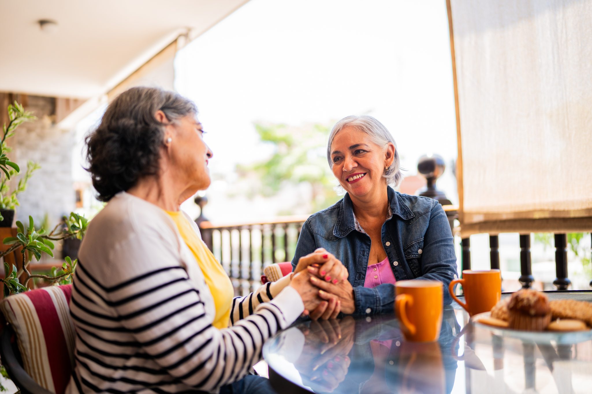 Two senior women talking over coffee