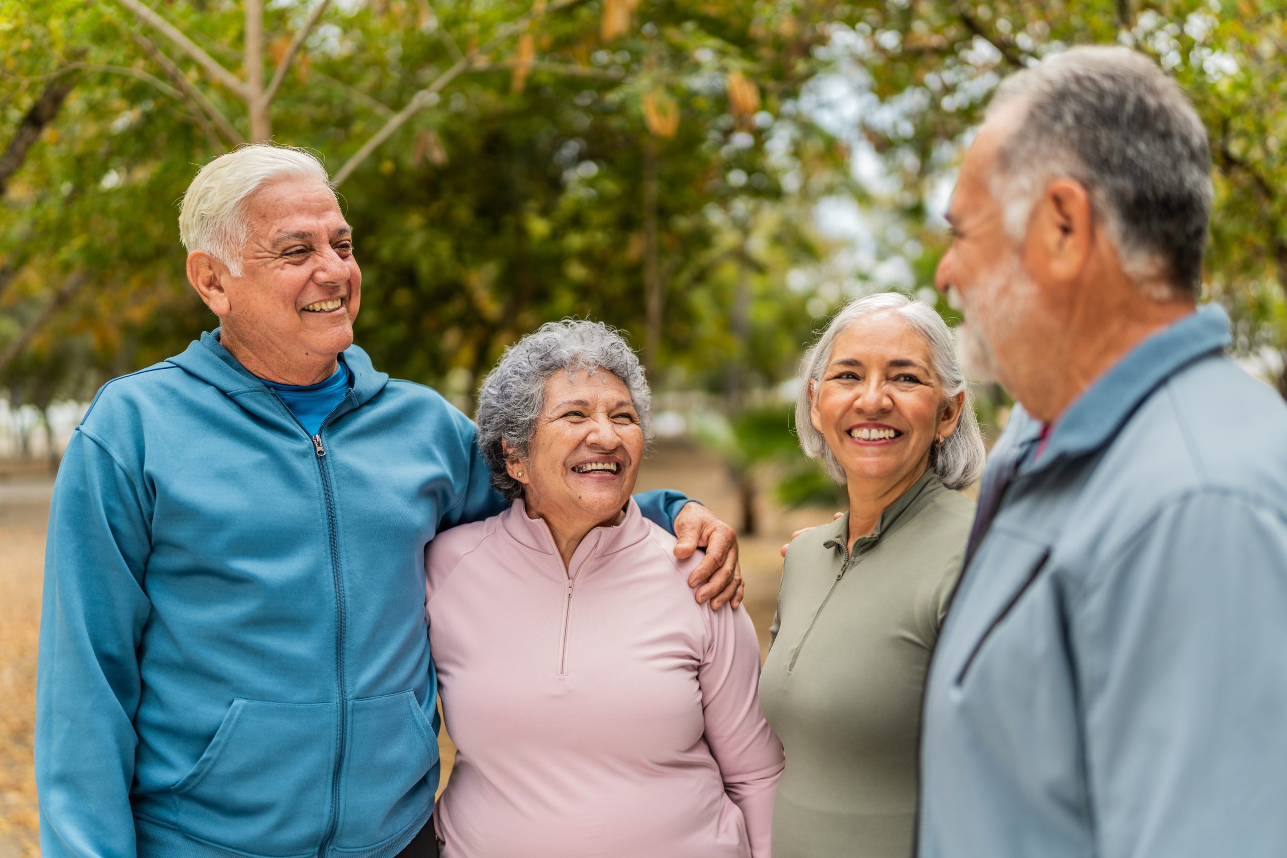 Four senior friends talking in a park